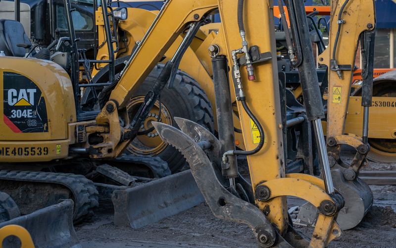 Mini digger and compact excavators for hire on a construction site (illustrative stock photo)