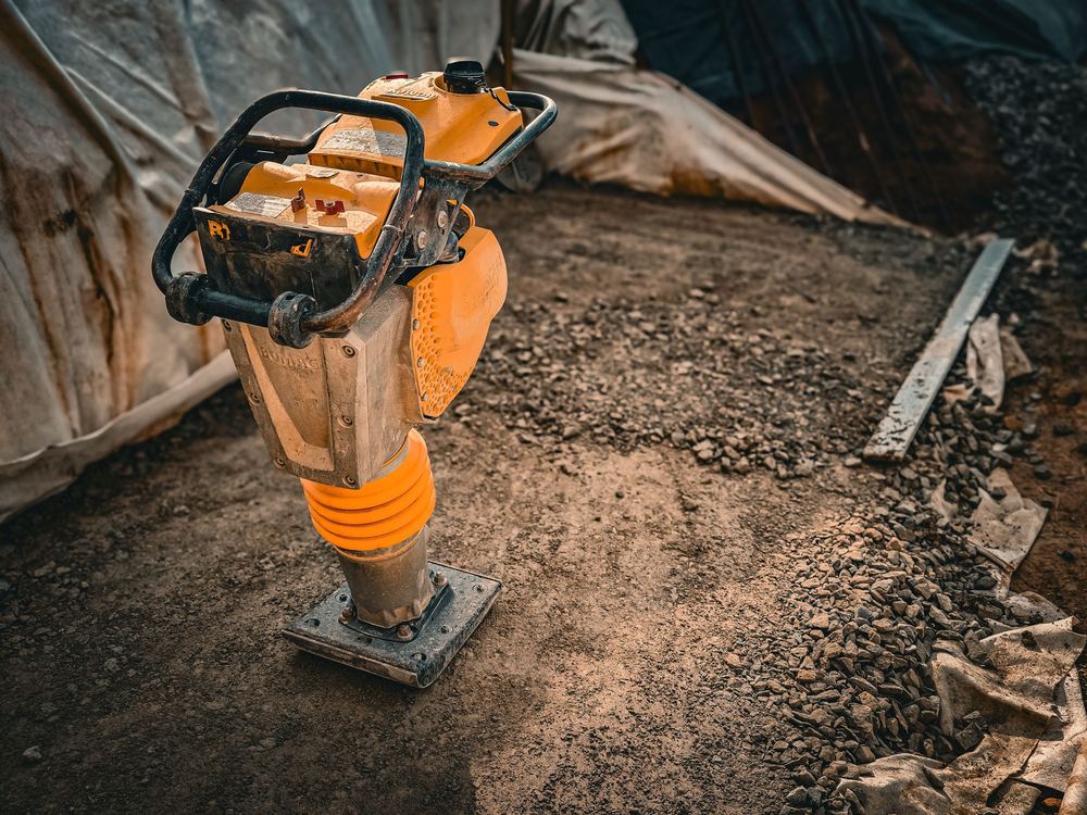 Trench rammer compacting ground on a building site, small plant available to hire (illustrative stock photo)