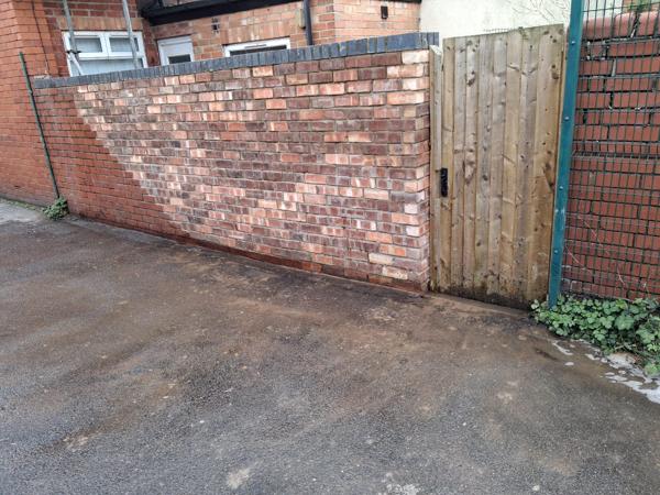 Rebuilt brick wall and gate to a rear yard