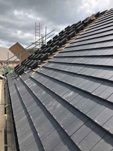 Interlocking concrete tiles being laid on a new-build roof – Staff4dshire Roofing Specialists